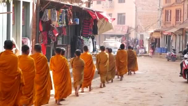 BHAKTAPUR, KATHMANDU, NEPAL - 18 жовтня 2018 Юні буддійські монахи процесії ходьби по милостині, діти збирають благодійні пропозиції. Щоденне вуличне життя, стародавнє східне місто після землетрусу. — стокове відео