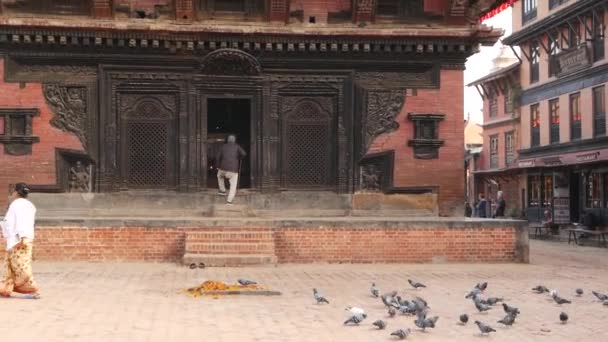 BHAKTAPUR, KATHMANDU, NEPAL - 18 oktober 2018 Newartsen bezoeken hindoetempels voor het aanbidden in traditionele kleding. Religieus dagelijks leven van de burger, oosterse oude stad na aardbeving — Stockvideo