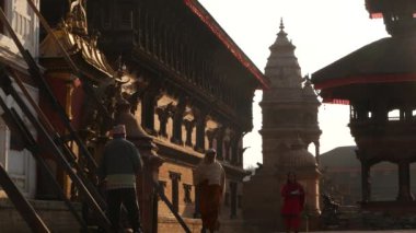 BHAKTAPUR, KATHMANDU, NEPAL - 18 Ekim 2018 Doğu antik kentinde deprem sonrası yaya trafiği. Ulusal giysili yerel newar insanları tapınağın yakınındaki sokaklara gidiyorlar.