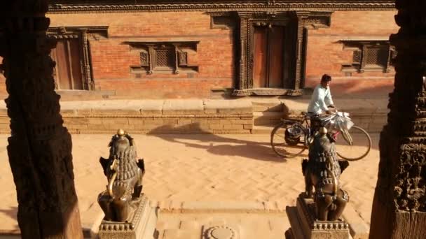 BHAKTAPUR, KATHMANDU, NEPAL - 18 oktober 2018 Dagelijks verkeer van voetgangers in oosterse oude stad na aardbeving. Lokale newar mensen in nationale kleren gaan in de straten in de buurt van tempel — Stockvideo