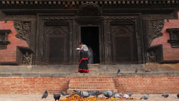 BHAKTAPUR, KATHMANDU, NEPAL - 18 October 2018伝統的な服を崇拝するために寺院を訪れる新しい人々。市民の宗教的な日常生活、地震後の東洋の古代都市 — ストック動画