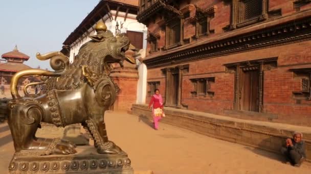 BHAKTAPUR, KATHMANDU, NEPAL - 18 października 2018 Dzienny ruch pieszych w orientalnym starożytnym mieście po trzęsieniu ziemi. Miejscowi newaryści w narodowych ciuchach wychodzą na ulice w pobliżu świątyni — Wideo stockowe