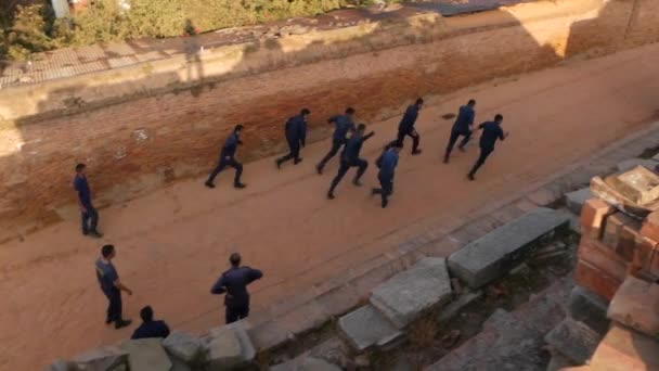 BHAKTAPUR, KATHMANDU, NEPAL - 18 Policías armados y soldados que llevan uniforme de entrenamiento. Poder del Partido Comunista, guardia de seguridad maoísta. Vida cotidiana ciudad antigua oriental después del terremoto — Vídeo de stock