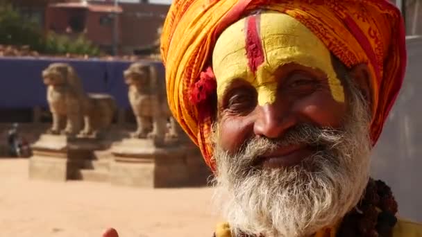 BHAKTAPUR, KATHMANDU, NEPAL - 18 October 2018 Senior Sadhu man with face painted. Elderly Sadhu man wearing colorful headband and with face colored being representative of asceticism. Pashipatinath. — Stock Video
