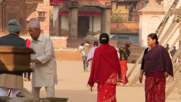 BHAKTAPUR, KATHMANDU, NEPAL - 18 oktober 2018 Asiatisk man och äldre kvinna i nationella kläder och gott humör leende, ta. Medborgarnas dagliga liv, orientalisk forntida stad efter jordbävningen — Stockvideo