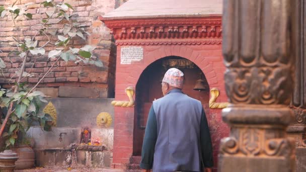 BHAKTAPUR, KATHMANDU, NEPAL - 18 października 2018 Newarczycy odwiedzający hinduską świątynię dla wielbiących tradycyjne stroje. Religijne codzienne życie obywateli, orientalne starożytne miasto po trzęsieniu ziemi — Wideo stockowe