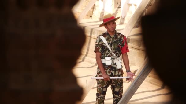 BHAKTAPUR, KATHMANDU, NEPAL - 18 oktober 2018 Man i uniform av väktare på torget. Ung man bär militär uniform och står på vakt 55 Fönsterpalatset på Durbar Square — Stockvideo