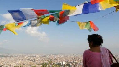 Katmandu, Nepal - 12 Ekim 2018. Cityscape arayan etnik kadın. Katmandu Vadisi, Swayambhunath Stupa, maymun Tapınağı cityscape yukarıdaki dizelerde çok renkli dua bayrakları sallayarak görünümü.