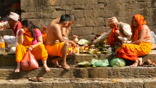 KATHMANDU, NEPAL - 8 DE OCTUBRE DE 2018 Sikha haciendo rituales de luto por los muertos, orando con brahman. Tonsure costumbre tradicional hindú. Puja en el Templo Pashupatinath. Hombres santos en los ghats bendición relativa — Vídeos de Stock