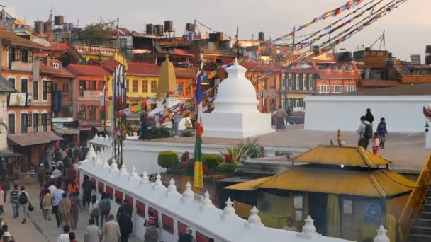 KATHMANDU, NEPAL - 12. října2018. Panorama na náměstí s Boudhanath Stupa. Krajina krásného orientálního města proti himalájským horám. turisté a věřící kráčí v západu slunce ligth — Stock video