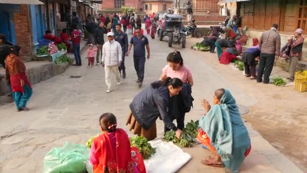 BHAKTAPUR, KATHMANDU, NEPAL - 18 de octubre de 2018 Personas asiáticas que venden productos en ropa nacional, mercado de templos de frutas de la mañana. Vida diaria del comercio callejero, ciudad antigua oriental después del terremoto. — Vídeos de Stock