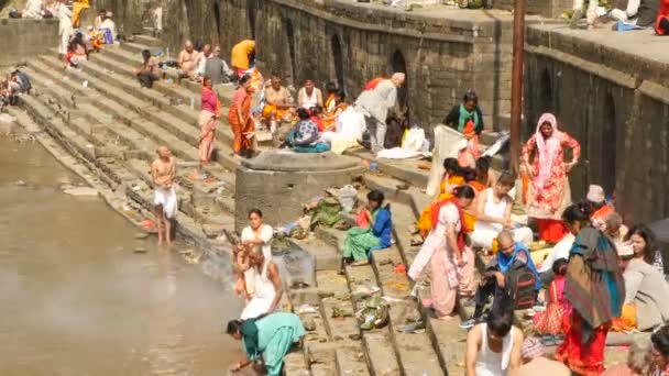 KATHMANDU, NEPAL - 8 OKTOBER 2018 Sikha gör sorgeritualer, ber med brahman. Tonsure hindu traditionell sed. Kom igen. Pashupatinattemplet. Sörjande, pilgrimer, kremeringsceremoni på spöken. — Stockvideo