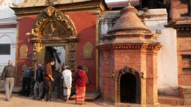 BHAKTAPUR, KATHMANDU, NEPAL - 18 Ekim 2018 Newar halkı 55 Windows, Golden Gate, Durbar meydanını ibadet için ziyaret ediyor. Dini günlük yaşam, depremden sonra antik doğu şehri.