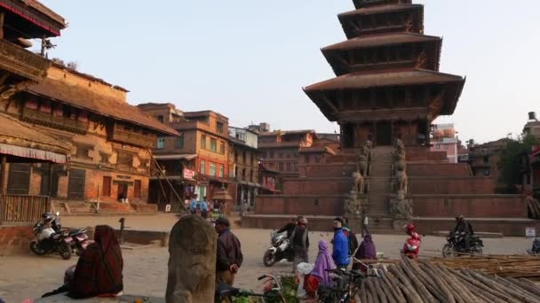 BHAKTAPUR, KATHMANDU, NEPAL - 18 Ekim 2018 Doğu antik kentinde deprem sonrası yaya trafiği. Ulusal giysili yerel newar insanları tapınağın yakınındaki sokaklara gidiyorlar. — Stok video