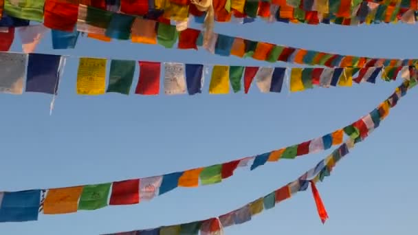 Coloridas banderas de oración ondeando en el viento en Boudhanath Stupa, Santa Pagoda, símbolo de Nepal y Katmandú con ojos de budas de golgen. atardecer ligth — Vídeo de stock