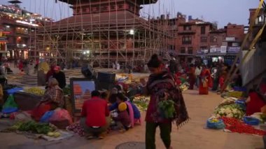BHAKTAPUR, KATHMANDU, NEPAL - 18 Ekim 2018 Asyalılar ulusal giysiler ve sabah sebze tapınağı pazarında ürün satıyorlar. Günlük ticaret hayatı, depremden sonra antik doğu şehri..