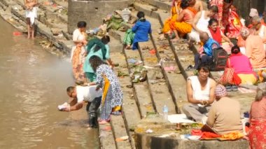 KATHMANDU, NEPAL - 8 Ekim 2018 Sikha Brahman 'la dua ederek yas ayinleri yapıyor. Tonsure Hindu geleneği. Puja. Pashupatinath Tapınağı. Yas tutanlar, hacılar, ghatlarda yakma töreni..