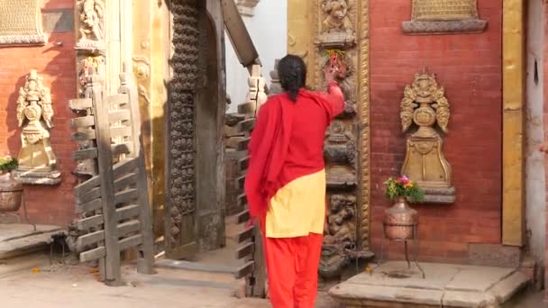 BHAKTAPUR, KATHMANDU, NEPAL - 18 oktober 2018 Newar besöker Kungliga slottet med 55 fönster, Golden gate, Durbar torg för dyrkan. Religiöst vardagsliv, orientalisk forntida stad efter jordbävningen — Stockvideo