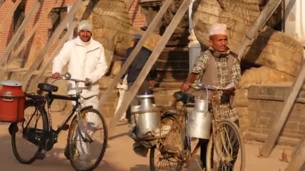 BHAKTAPUR, KATHMANDU, NEPAL - 18 de octubre de 2018 Tráfico diario de peatones en la antigua ciudad oriental después del terremoto. Newar local hombre con bicicleta va en las calles cerca del templo — Vídeos de Stock