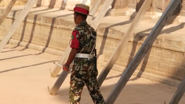BHAKTAPUR, KATHMANDU, NEPAL - 18. října 2018 Muž v uniformě strážce na náměstí paláce. Mladý muž ve vojenské uniformě a stojí na stráži 55 Window Palace na náměstí Durbar — Stock video