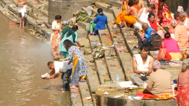 KATHMANDU, NEPAL - 8 OKTOBER 2018 Sikha gör sorgeritualer, ber med brahman. Tonsure hindu traditionell sed. Kom igen. Pashupatinattemplet. Sörjande, pilgrimer, kremeringsceremoni på spöken. — Stockvideo