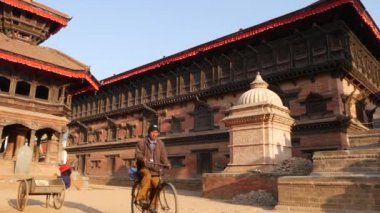 BHAKTAPUR, KATHMANDU, NEPAL - 18 Ekim 2018 Doğu antik kentinde deprem sonrası yaya trafiği. Ulusal giysili yerel newar insanları tapınağın yakınındaki sokaklara gidiyorlar.