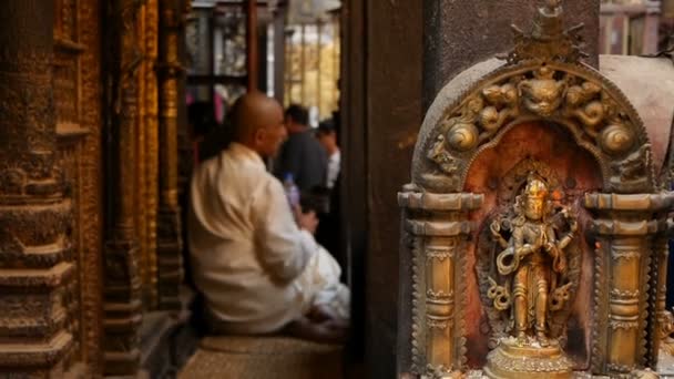 2018 년 7 월 7 일에 확인 함 . LALITPUR, NEPAL - 7 OCTOBER 2018 Decorative sculpture on entry to Hindu temple. 힌두교 사원에 있는 반짝 이는 오래 된 조각품과 안에 있는 승려들. — 비디오