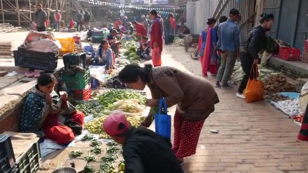 BHAKTAPUR, KATHMANDU, NEPAL - 18 Οκτωβρίου 2018 Ασιάτες που πωλούν προϊόντα σε εθνικές ενδυμασίες, αγορά πρωινού ναού με φρούτα. Daily street trade life, ανατολική αρχαία πόλη μετά το σεισμό. — Αρχείο Βίντεο