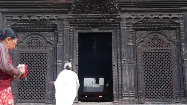 BHAKTAPUR, KATHMANDU, NEPAL - 18. října 2018 Noví lidé navštěvují hinduistický chrám za účelem uctívání v tradičních šatech. Náboženský každodenní život občanů, orientální starobylé město po zemětřesení — Stock video