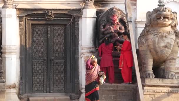 BHAKTAPUR, KATHMANDU, NEPAL - 18 October 2018 Newar people visit Hindu Monkey God Hanuman in Durbar Royal Palace for worshiping. Religious oriental ancient city partially destroyed after earthquake — Stock Video