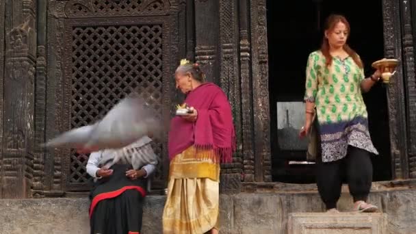 BHAKTAPUR, KATHMANDU, NEPAL - 18 oktober 2018 Newar people visiting hindu temple for worshiping in traditional clothing. Religiöst vardagsliv medborgare, orientalisk forntida stad efter jordbävningen — Stockvideo