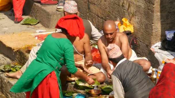 Kathmandu, Nepál - 8 října 2018 Vlastimil dělat rituály oplakávali mrtvé, modlil se s brahman. Postřižení hinduistické tradici. Puja v Pashupatinath Temple. Svatí muži na Ghát požehnání relativní — Stock video