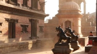 BHAKTAPUR, KATHMANDU, NEPAL - 18 Ekim 2018 Doğu antik kentinde deprem sonrası yaya trafiği. Ulusal giysili yerel newar insanları tapınağın yakınındaki sokaklara gidiyorlar.