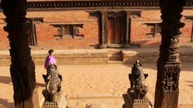 BHAKTAPUR, KATHMANDU, NEPAL - 18 Ekim 2018 Doğu antik kentinde deprem sonrası yaya trafiği. Ulusal giysili yerel newar insanları tapınağın yakınındaki sokaklara gidiyorlar.
