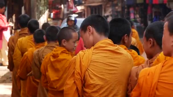 BHAKTAPUR, KATHMANDU, NEPAL - 18 жовтня 2018 Юні буддійські монахи процесії ходьби по милостині, діти збирають благодійні пропозиції. Щоденне вуличне життя, стародавнє східне місто після землетрусу. — стокове відео