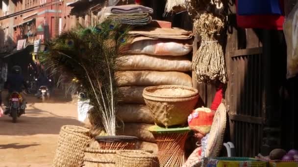 BHAKTAPUR, NEPAL - 13 DE OUTUBRO DE 2018 Mulher com criança no quintal da casa. Mulher étnica com bebê, abundância de cestas de vime para venda em luz solar brilhante. vida diária, oriental antiga cidade após terremoto — Vídeo de Stock