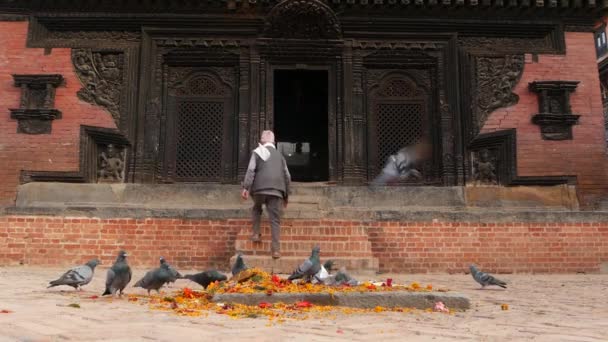 BHAKTAPUR, KATHMANDU, NEPAL - 18. října 2018 Noví lidé navštěvují hinduistický chrám za účelem uctívání v tradičních šatech. Náboženský každodenní život občanů, orientální starobylé město po zemětřesení — Stock video