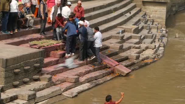 KATHMANDU, NEPAL - 8 OCTOBER 2018: Місцеві індуси, традиційна церемонія кремації на вогняних капелюхах на березі річки Багматі в храмі Пашупатінатхат. — стокове відео