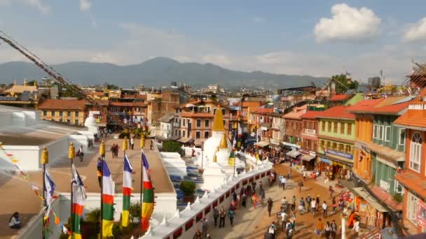 KATHMANDU, NEPAL - 12. října2018. Panorama na náměstí s Boudhanath Stupa. Krajina krásného orientálního města proti himalájským horám. turisté a věřící kráčí v západu slunce ligth — Stock video