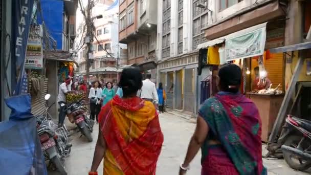 KATHMANDU, NEPAL - 8. OKTOBER 2018 Frauen in bunten Nationalkleidern gehen auf der Straße. Rückansicht von ethnischen Frauen in hellen nationalen Kleidern indischen Sari. Asan-Markt. — Stockvideo