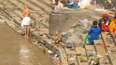 KATHMANDU, NEPAL - 8 Ekim 2018 Sikha Brahman 'la dua ederek yas ayinleri yapıyor. Tonsure Hindu geleneği. Puja. Pashupatinath Tapınağı. Yas tutanlar, hacılar, ghatlarda yakma töreni..