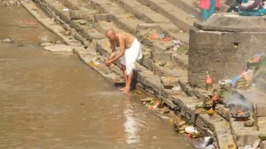 KATHMANDU, NEPAL - 8 Ekim 2018 Sikha Brahman 'la dua ederek yas ayinleri yapıyor. Tonsure Hindu geleneği. Puja. Pashupatinath Tapınağı. Yas tutanlar, hacılar, ghatlarda yakma töreni..