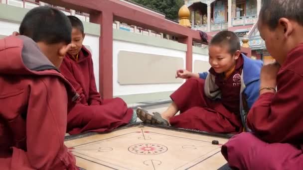 Bhaktapur, Kathmandu, Nepal - 18 oktober 2018 vrolijke jonge jongens tafelspel spelen in de werf van de tempel. Glimlachen van boeddhistische monniken in het klooster childrens in Azië in gewaad. — Stockvideo