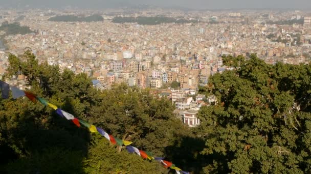 Sventolando bandiere di preghiera contro il paesaggio urbano. Veduta di sventolare bandiere di preghiera multicolore sulle corde sopra il paesaggio urbano della valle di Kathmandu, Swayambhunath Stupa Monkey Temple, Nepal . — Video Stock