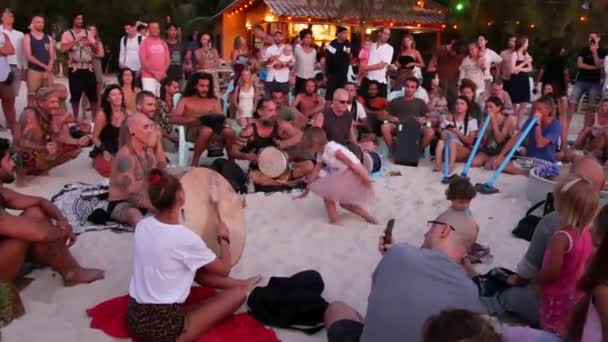 Phangan, Thajsko - 23 února 2019 Zen Beach. Šťastní lidé hrát na kytaru a bicí na tropický ráj letní pobřeží při západu slunce, obklopené mnoha lidí. Hudební jam, pojetí svobody, sociální volný čas — Stock video