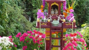 Tahta minyatür koruyucu aile evi. Küçük Budist tapınağı, renkli çiçek çelenkleri. San phra phum servet getirmek için dikildi. Geleneksel saygı hayvani ritüeller, dua törenleri