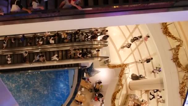 Бангкок, Таиланд - 18 ДЕКАБРЯ, 2018: Сиам Парагон азиатский торговый центр интерьера. Толпы людей на эскалаторах торгового центра. Люди спешат по магазинам на современной площади. Потребление товаров — стоковое видео