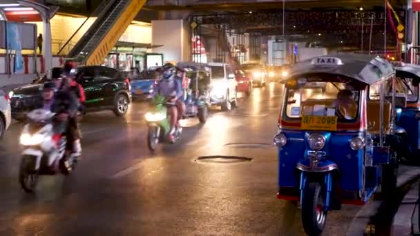 BANGKOK, THAILAND - 18 ARALIK 2018: Geleneksel Tayland taksisi - Tuk Tuk yol boyunca turistleri bekliyor. Kalabalık şehrin gece trafiği. Asya ülkesinin sembolü, eşsiz bir araç. — Stok video