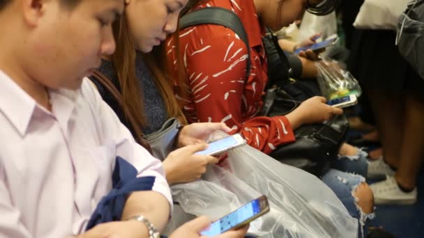 BANGKOK, Tajlandia - 18 GRUDZIEŃ, 2018: Pasażer na stacji BTS Skytrain w Bangkoku Tajlandia, wszyscy patrząc w dół na smartfona czekając na pociąg BTS — Wideo stockowe