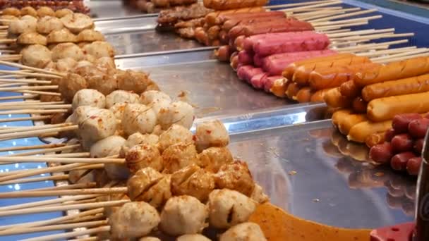 Mercado tradicional asiático de comida noturna na Tailândia. Almôndegas de churrasco e outros lanches deliciosos exóticos para navegar. Pronto para comer comida — Vídeo de Stock